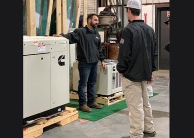 E.E.S. Inc. | employees looking at generators in warehouse