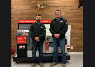 E.E.S. Inc. | employees standing in front of generator display