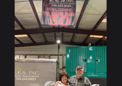 E.E.S. Inc. | couple standing under black and white 50 years banner