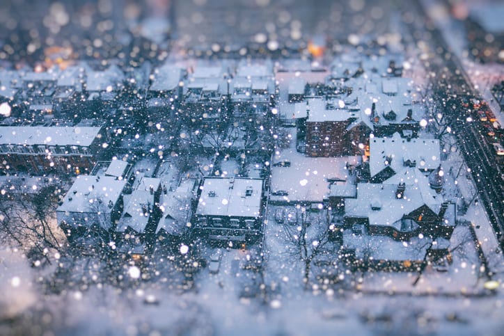 E.E.S. Inc. | overhead view of a town at dusk with snow falling